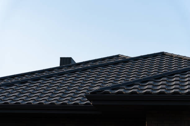 istock The image showcases a modern roof featuring sleek black metal tiles, highlighting construction details against a bright blue sky. A chimney is also visible 2178235773