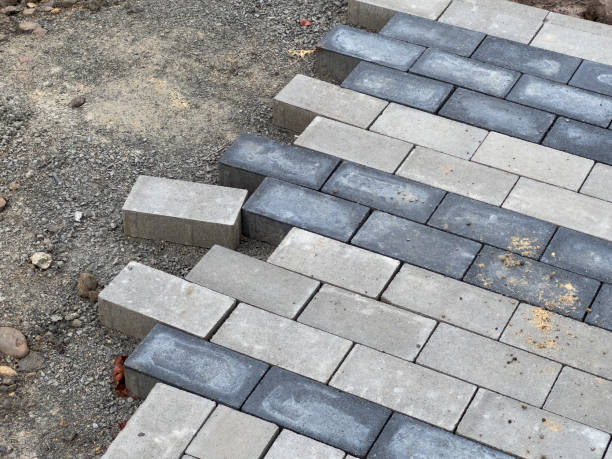 istock Workers are carefully laying down paving stones on a gravel foundation, progressing through the pavement repair project in this residential neighborhood 2178235813