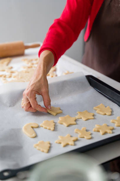 istock Woman arranging christmas cookies on baking sheet 2178236975
