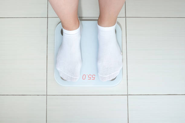 istock A Person Weighing Themselves on a Digital Scale in a Comfortable and Clean Environment 2178240657
