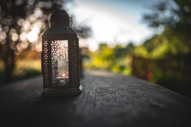 istock Oil, candle lantern on a wooden table on a camping site. 2178242280