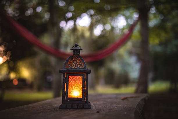 istock Oil, candle lantern on a wooden table on a camping site. 2178242374