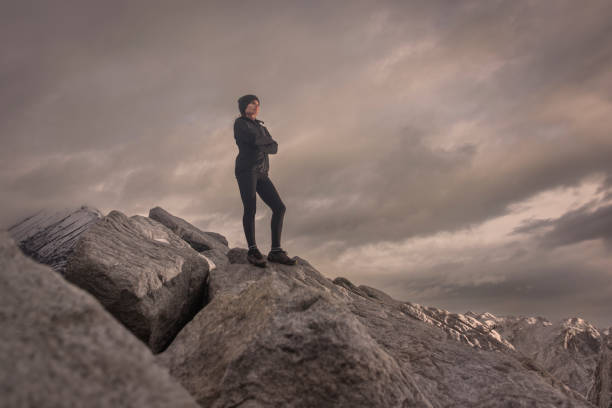 istock Woman standing on a rocky mountain looking at the view 2178243865