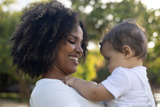 istock Mother is smiling at her baby while standing in a park 2178244814