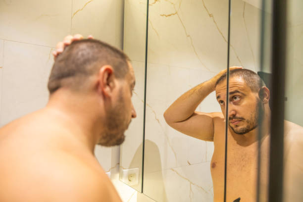 istock Men is looking at the mirror in the bathroom. 2178246416
