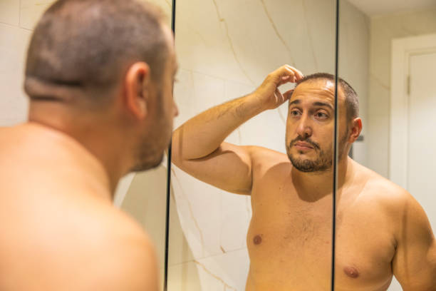 istock Men is looking at the mirror in the bathroom. 2178246435