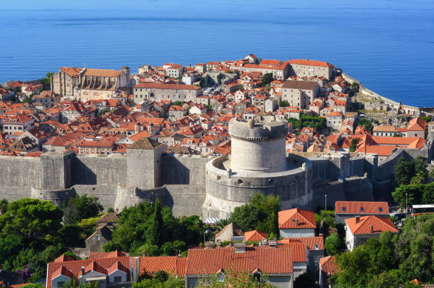 Dubrovnik historical old town and city walls, Croatia Dubrovnik, Croatia, view over the red tiled roofs of the historical walled Old town, the Minceta Tower and blue Adriatic sea fort minceta dubrovnik stock pictures, royalty-free photos & images