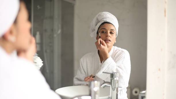 istock Beautiful woman applying makeup in bathroom 2178246841