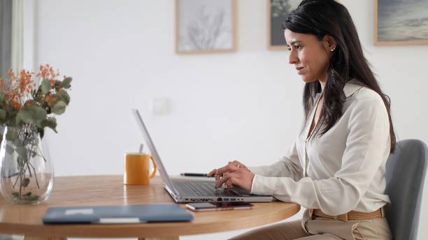 istock Businesswoman working from home sitting at desk using laptop 2178246859
