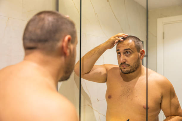 istock Men is looking at the mirror in the bathroom. 2178247913