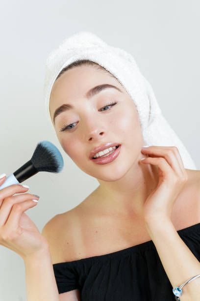 istock A woman is applying makeup in front of a mirror 2178249118