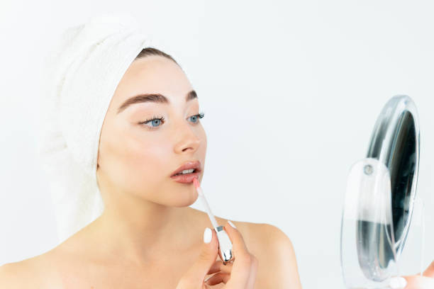 istock A woman is applying makeup in front of a mirror 2178249130