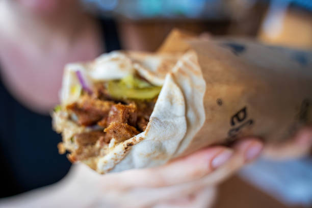 istock Close Up of a Delicious Shawarma Wrap Held in Hand 2178249428
