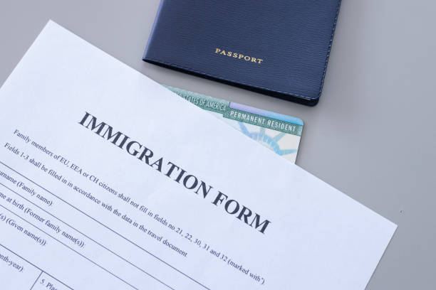 istock Immigration form and passport on desk. Application to register permanent residence. 2178250074