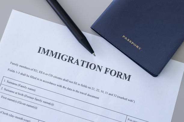 istock Immigration form and passport on desk. Application to register permanent residence. 2178250079