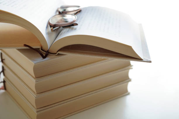 Open blank book on top of stacks of books, Mock up