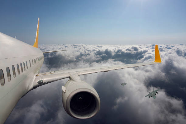 istock F-22 jet aircraft escorting commercial passenger airplane. 2178253565