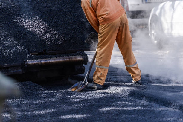 istock A construction worker spreading asphalt on a road during a sunny day in an urban area, ensuring smooth surface for vehicles 2178256407