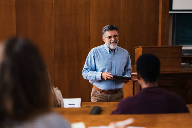 professor engaging with students in lecture hall setting - professor da faculdade imagens e fotografias de stock