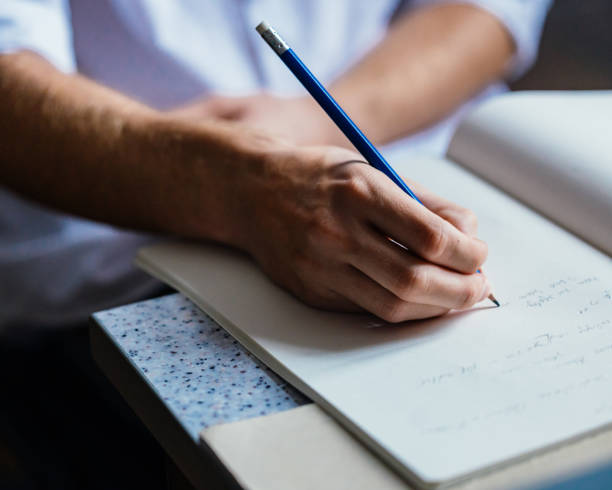 istock Close-Up of Hand Writing in Notebook with Pencil 2178258071