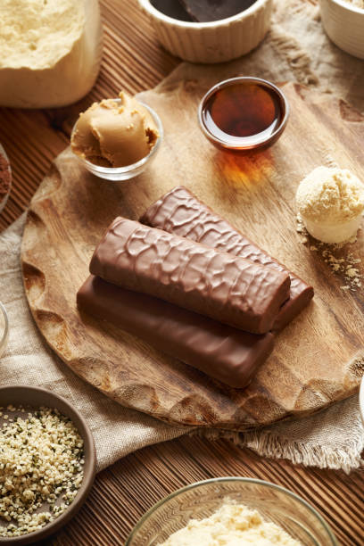 istock Protein chocolate bars with ingredients - whey protein powder, peanut butter, hemp seeds, cocoa and maple syrup 2178258752