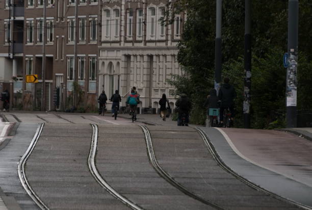 istock Bicyclists riding away on tramway tracks during morning commute - 1 2178264131