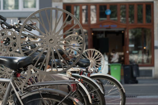 Decorative alloy wheels hanging over bicycle parling rack in central Amsterdam