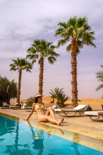 istock Woman relaxing by a pool in a desert resort. 2178265514