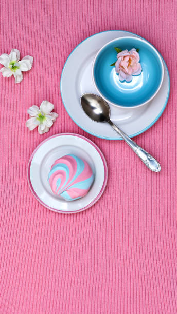 istock Vertical banner with colorful striped fluffy marshmallows served on saucers on a pink knitted background, sweet addiction, taste temptation, pleasure for one 2178266180