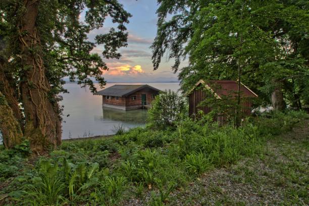 istock Wooden Boathouse on a Serene Lake at Sunset 2178271247