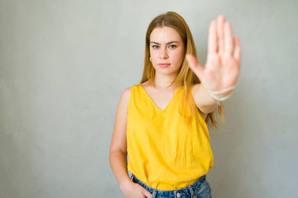 istock Serious young woman signals to stop, expressing refusal and protest 2178272071
