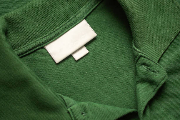 istock Blank white laundry care clothes label on green shirt fabric texture background 2178273340