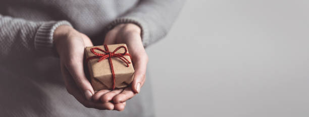 istock Hands holding little gift with red bow. Close up. 2178273346