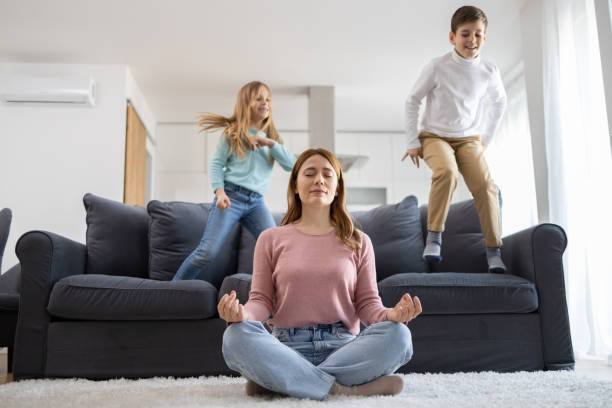 istock Meditating mother with playful children 2178273436