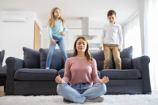 istock Calm mother meditating with children at play 2178273444