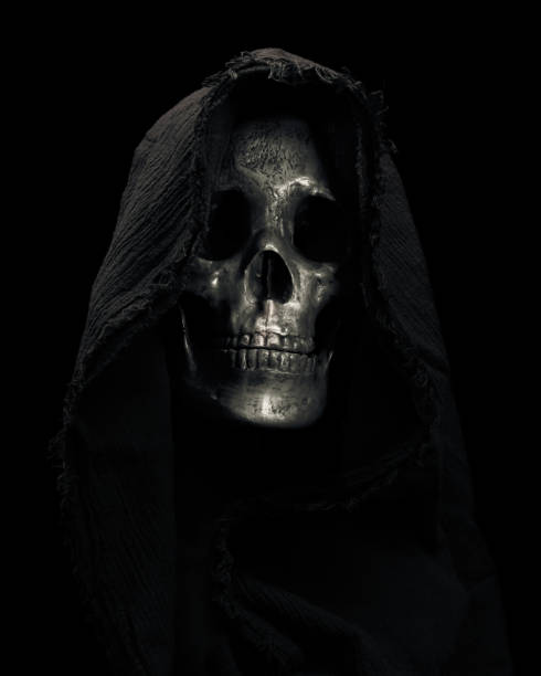 istock Hooded Grim Reaper figure emerging from the shadows. Terrifying human skull, haunted spirt, or frightening ghost rising from dead. 2178274160