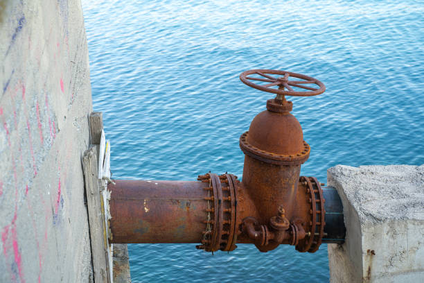 istock Rusty water pipe valve by sea wall capturing industrial decay in a coastal setting 2178274314
