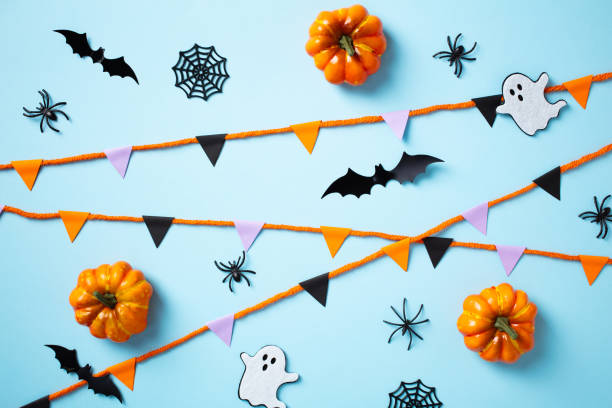 istock Happy Halloween holiday concept. Flat lay composition with bunting garland, pumpkins, ghosts, bats, spiders on blue background 2178275983