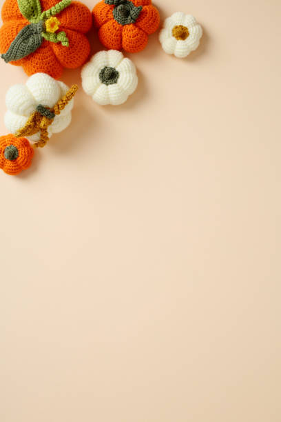 istock Handmade crochet pumpkins on a neutral vertical background 2178276592