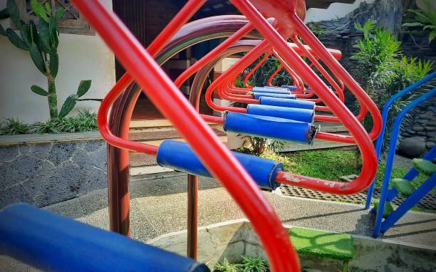 Red triangular monkey bars on the outdoor playground. Hanging games to train children's physicality.