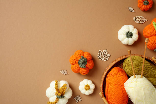 istock Top view handcrafted autumn decorations featuring crocheted pumpkins, yarn, and knitting needles on a warm brown background. Flat lay cozy home decor, and creative fall crafts 2178276815