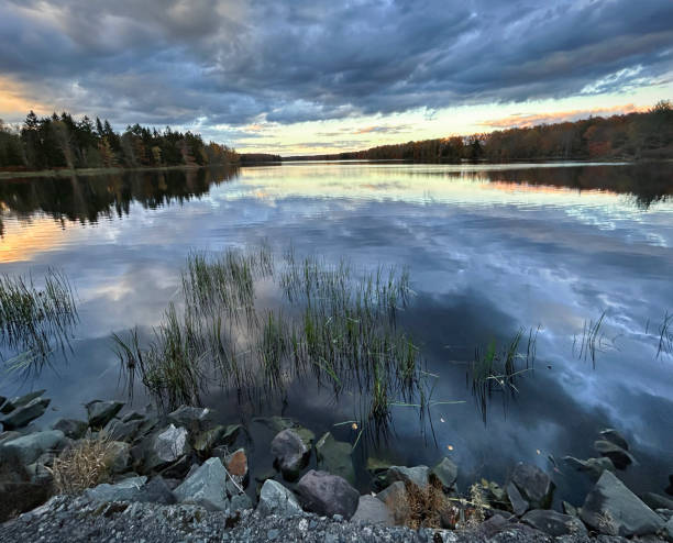 istock Mirroring autumn's glory. Poconos lake reflects dramatic sky and fall foliage during tranquil evening. 2178278359