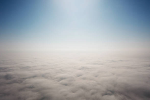 Breath-taking aerial view over white thick and soft clouds floating against mountain peaks