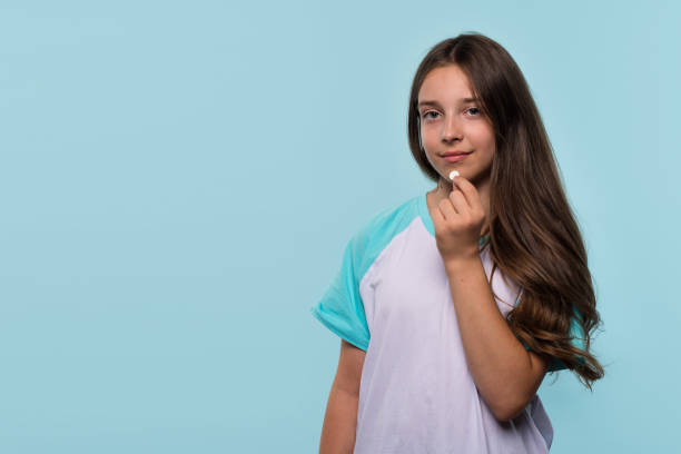 istock Young girl holds white pill near her mouth 2178296563