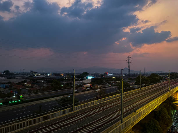 istock Sunset over a cityscape with train tracks and a highway 2178298393