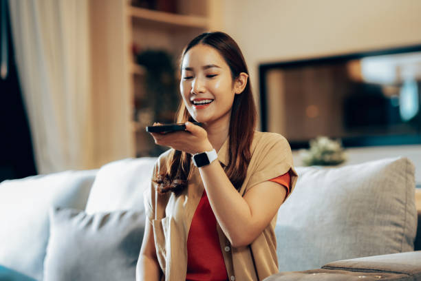 Woman Engaging with Voice Command Feature on Smartphone in Modern Home