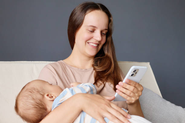 istock Happy pretty mommy cuddling small kid daughter or son using smartphone for internet shopping or checking social network at home loving young mother embracing little child and scrolling online 2178299040