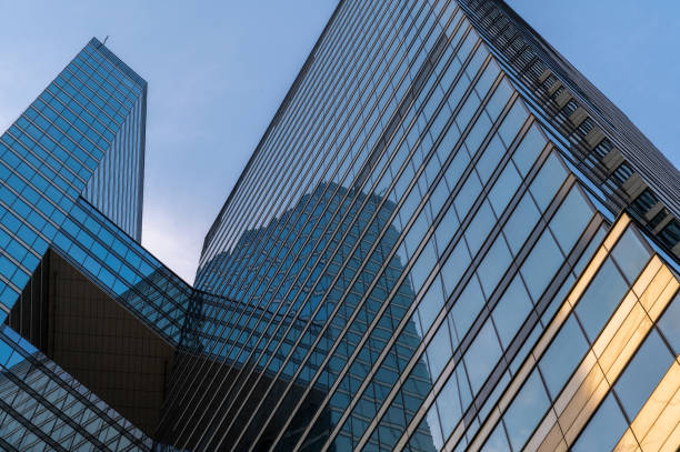 Angled view of modern skyscrapers in business district against blue sky. Looking Up high-rise office buildings.