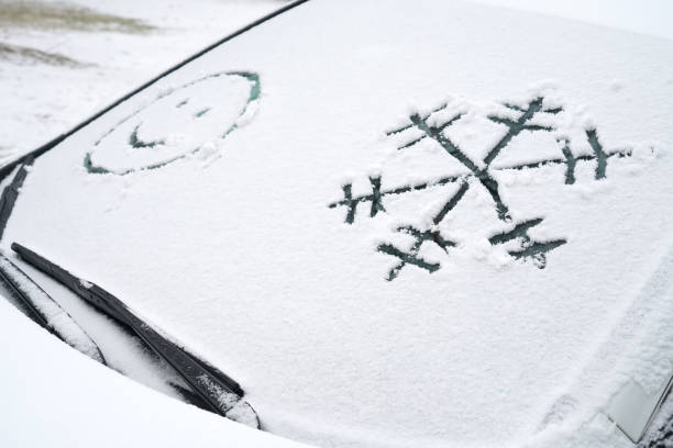 Snowflake and smile face drawing on the window of car