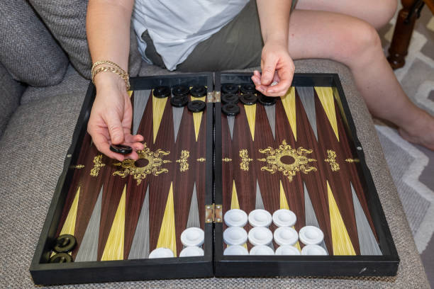 istock Woman playing backgammon on sofa, backgammon playground and dice. 2178301205